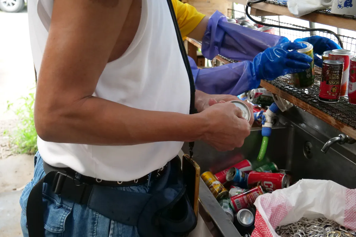 作業台で空き缶を扱う二人の手元